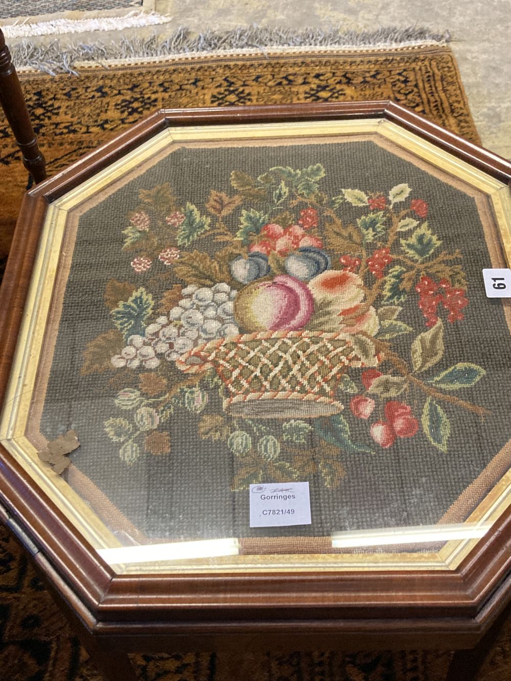 An grois point tapestry panel, inset in the top of a hexagonal mahogany table, width 54cm, depth 48cm, height 48cm